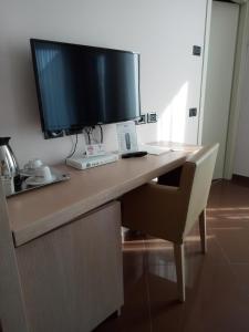 un escritorio con un monitor de ordenador encima en Hotel Chiaraluna en Civitanova Marche