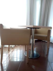 un tavolo da pranzo e 2 sedie in camera di Hotel Chiaraluna a Civitanova Marche