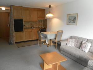 ein Wohnzimmer mit einem Sofa und einem Tisch in der Unterkunft Apartment Ammerten A17 by Interhome in Lenk im Simmental