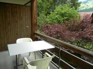 a white table and chairs on a balcony at Apartment Ammerten A17 by Interhome in Lenk