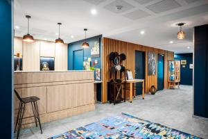 un hall avec un bar aux murs bleus dans l'établissement Residhome Saint Ouen, à Saint-Ouen