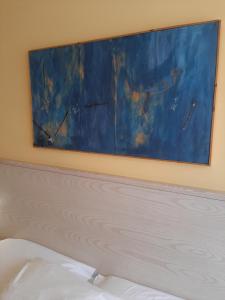 un dipinto appeso sopra un letto in una camera da letto di Hotel Chiaraluna a Civitanova Marche