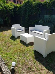 three white chairs and a table in a yard at SUNFLOWER cosy cottage once GIRASOLE in Monterosso al Mare