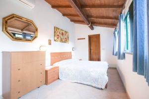 a bedroom with a bed and a mirror on the wall at SUNFLOWER cosy cottage once GIRASOLE in Monterosso al Mare