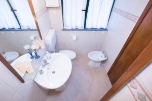 a white bathroom with a sink and a toilet at SUNFLOWER cosy cottage once GIRASOLE in Monterosso al Mare