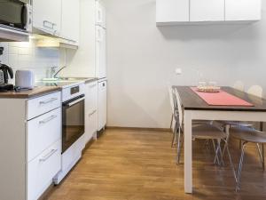 LahdenperäにあるHoliday Home Kerttu by Interhomeのキッチン(白いキャビネット、テーブル、椅子付)