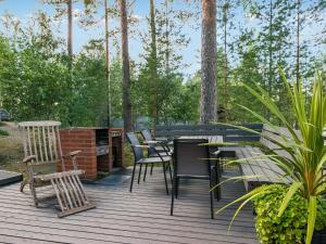 una terrazza con tavolo, sedie e alberi di Holiday Home Kissankulma by Interhome a Mouhu