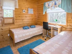 1 Schlafzimmer mit 2 Betten und einem Schreibtisch in einer Blockhütte in der Unterkunft Holiday Home Polaria by Interhome in Niittymaa