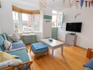 a living room with a couch and a tv at 2 Linden Terrace in Sandown