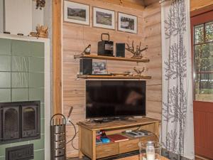 a living room with a television on a wooden wall at Holiday Home Kurjenpuola by Interhome in Äkäslompolo