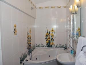 Baño blanco con bañera y lavamanos en Guesthouse Elizabeth, en Samokov