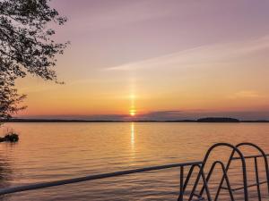 Blick auf den Sonnenuntergang von einem Boot auf einem See in der Unterkunft Holiday Home Villa piranniemi by Interhome in Onkamon Kannas