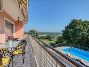 a balcony with a table and chairs and a swimming pool at Holiday Home Legović by Interhome in Kaštelir