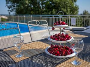 dos platos de cerezas en una mesa con copas de vino en Holiday Home Legović by Interhome, en Kaštelir