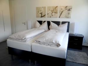 sypialnia z 2 łóżkami z białą pościelą i poduszkami w obiekcie Apartment Barbara West by Interhome w mieście Engelberg