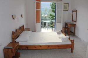 a bedroom with a large bed and a balcony at Theodora Studios in Yénion
