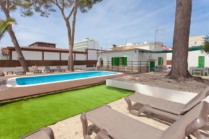 een achtertuin met een zwembad en een huis bij Villa Els Pins in El Arenal