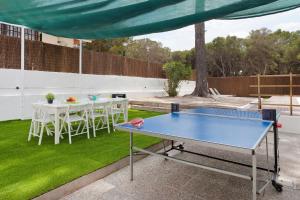 una mesa de ping pong en un patio con un mantel en Villa Els Pins, en El Arenal