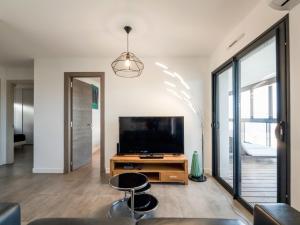 a living room with a flat screen tv on a wooden table at Apartment Château-5 by Interhome in Porto-Vecchio