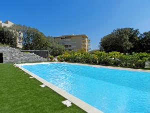 a large blue swimming pool next to a building at Apartment Château-5 by Interhome in Porto-Vecchio