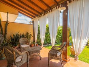 patio con sedie in vimini e un tavolo sul portico di Holiday Home Renza by Interhome a Pietrasanta