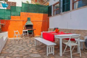 eine Terrasse mit einem Tisch, Stühlen und einem Kamin in der Unterkunft Llinya 7 in El Arenal