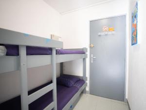 a bunk bed room with purple bunk beds and a door at Studio Le Grand Galion-3 by Interhome in Le Grau-du-Roi