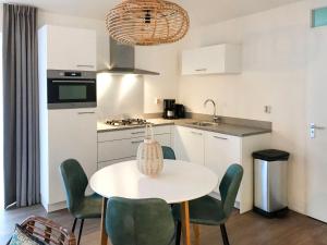 a kitchen with a table and chairs in a kitchen at Holiday Home Citta Romana-1 by Interhome in Hellevoetsluis