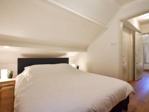 ein Schlafzimmer mit einem großen weißen Bett in einem Zimmer in der Unterkunft Chalet Oosterduinen by Interhome in Norg