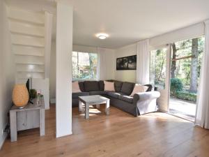 a living room with a couch and a table at Chalet Oosterduinen by Interhome in Norg