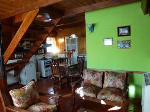 sala de estar con paredes verdes, mesa y sillas en Villa El Radal en San Martín de los Andes