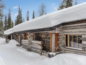 a log cabin with snow on the roof at Holiday Home Aihkelo by Interhome in Luosto