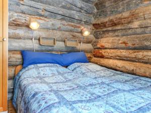 a bedroom with a bed in a wooden wall at Holiday Home Aihkelo by Interhome in Luosto