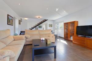 a living room with a couch and a tv at Bellavista in Cala Blava