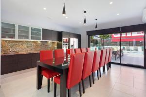 a dining room with a black table and red chairs at Villa Maravilla in San Francesch