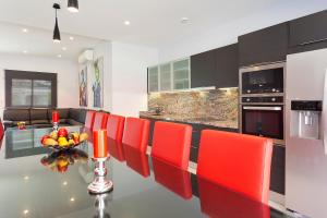 a kitchen with red chairs and a table with a dining room at Villa Maravilla in San Francesch