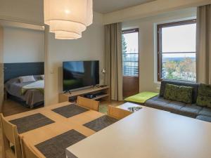 a living room with a dining table and a television at Holiday Home Nordic chalet 9102 by Interhome in Ylläsjärvi