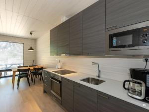 cocina con fregadero, microondas y mesa en Holiday Home Kasnäs marina b11 by Interhome, en Kasnäs