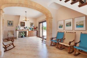 a living room with a fireplace and blue chairs at Sa Murtera in Manacor