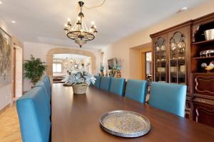 a dining room with a table and blue chairs at Sa Murtera in Manacor +27 photos
