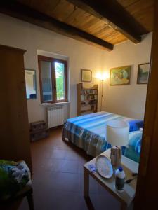 a bedroom with a bed and a table with a lamp at Casale ristrutturato 3 Km Tropea in Santa Domenica