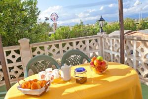 a yellow table with a bowl of bread and fruit at Cas Fideuer in La Aranjasa
