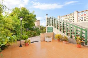 a patio with a white chair and a staircase with plants at Cas Fideuer in La Aranjasa