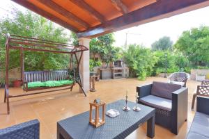 a patio with a swing and a table and chairs at Cas Fideuer in La Aranjasa