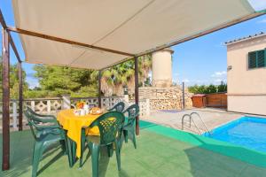 eine Terrasse mit einem Tisch, Stühlen und einem Pool in der Unterkunft Cas Fideuer in Palma de Mallorca