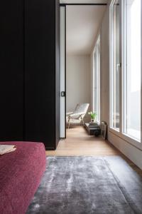una camera con un letto e una sedia e una finestra di BMORE Duomo - Luxury Apartments near Duomo a Milano