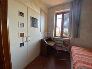 a bedroom with a bed and a desk and a window at Casale ristrutturato 3 Km Tropea in Santa Domenica
