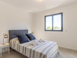 a white bedroom with a large bed with a window at Apartment St Joseph-1 by Interhome in Porto-Vecchio