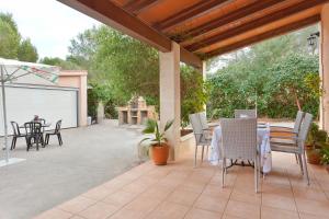 a patio with a table and chairs on it at Villa Angela in Urbanicacion ses palmeres