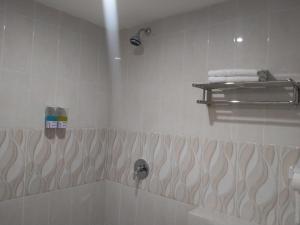 uma casa de banho com uma banheira e um chuveiro com uma toalha em GRANADA INN PALU em Palu